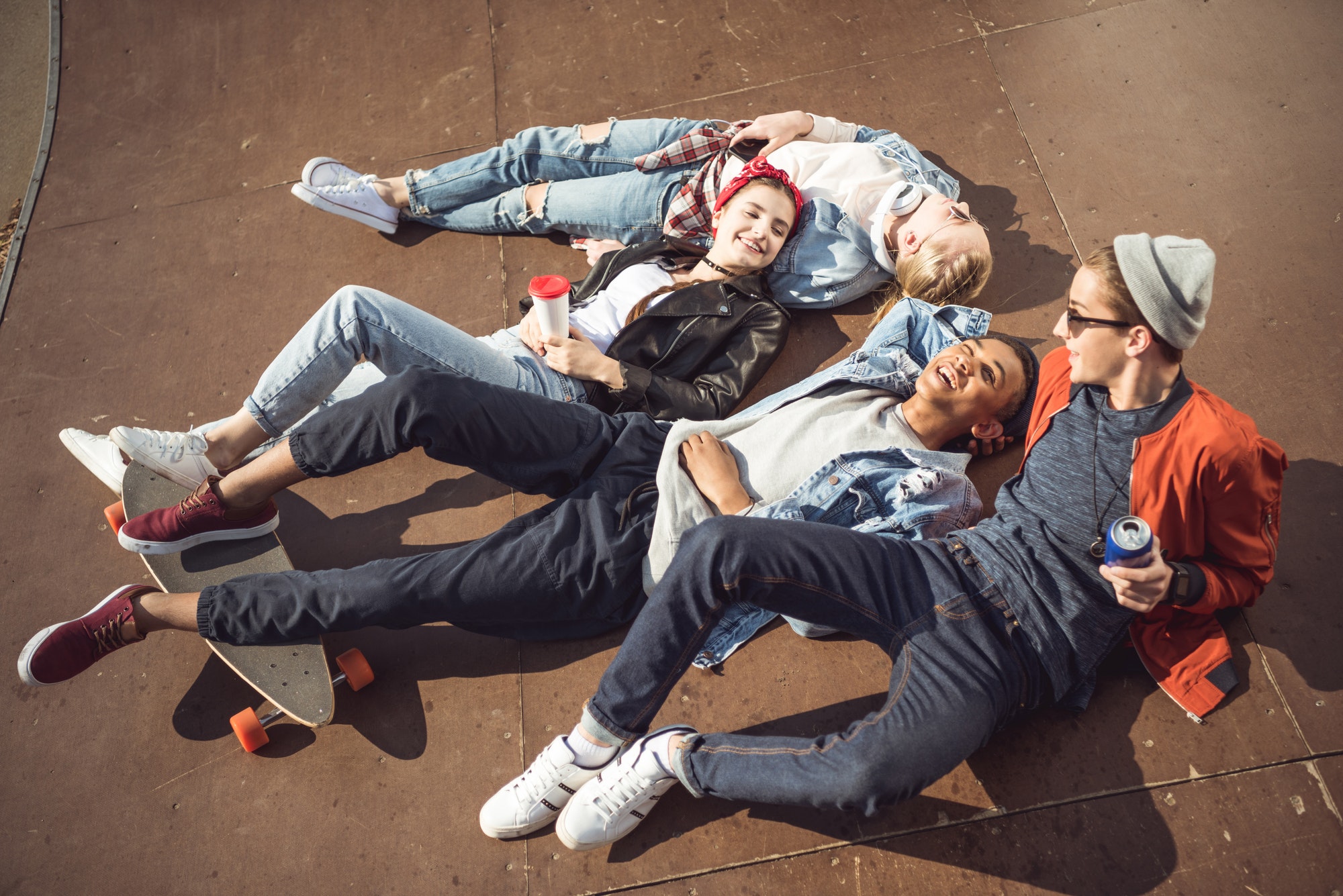 High Angle View of Teenagers Group Lying together and Resting at Skateboard Park